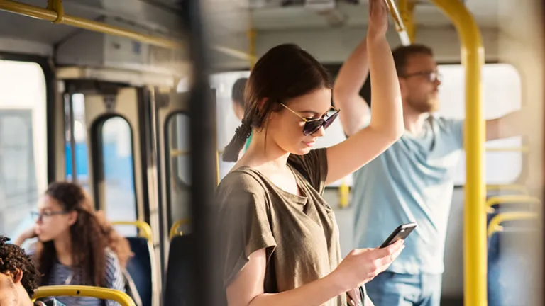 mujer en ómnibus usando celular