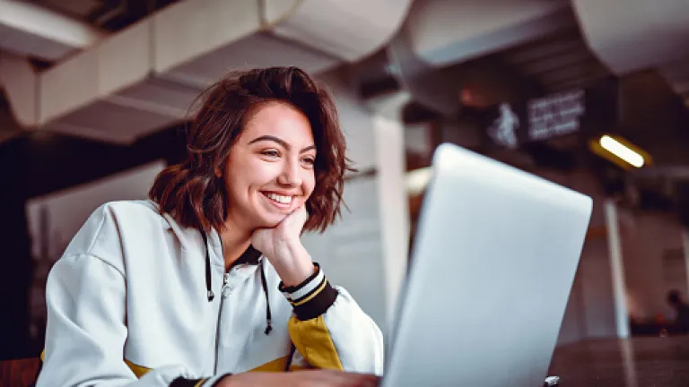 mujer mirando compu y sonriendo