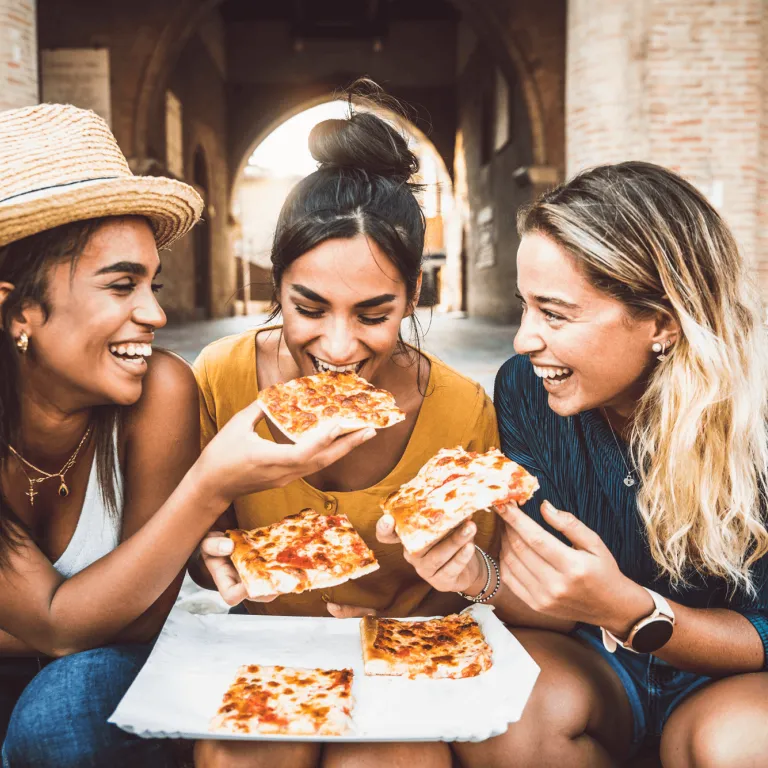 tres amigas comiendo pizza
