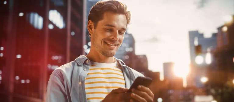 hombre mirando el celular en la ciudad