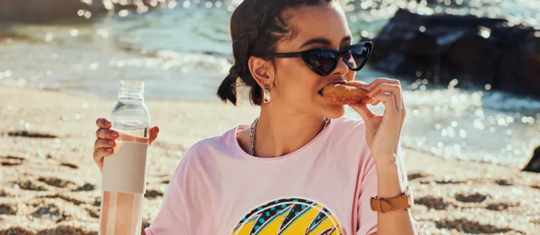 mujer comiendo en la playa