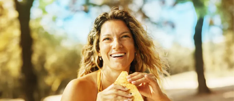 mujer comiendo en la playa