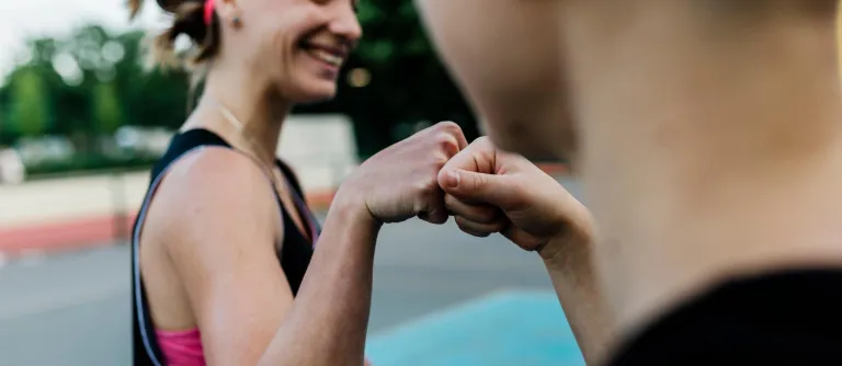 Mujer y hombre chocando puños