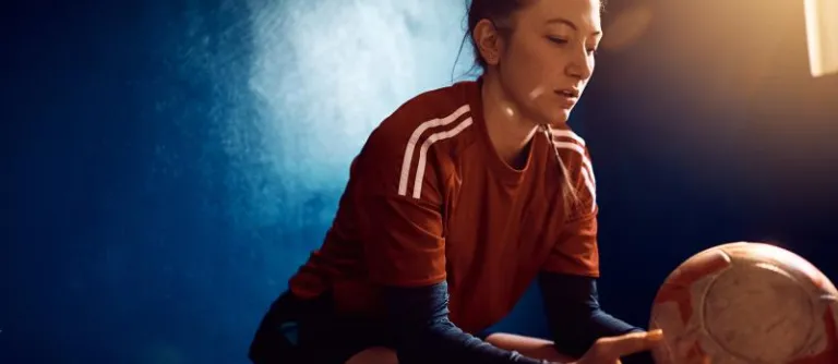 mujer sentada con pelota en la mano