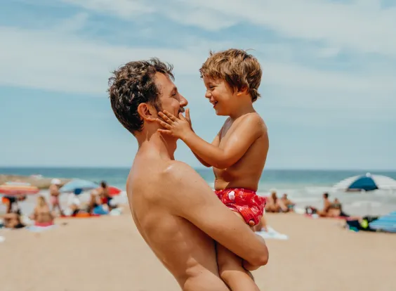 padre e hijo en la playa sonriendo