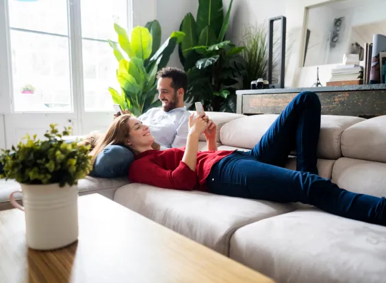 pareja mirando celular en una casa